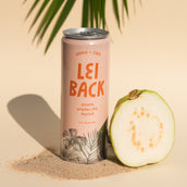 A can of Lei Back Guava Sparkling Water next to a bisected guava fruit