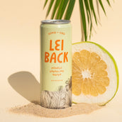 A can of Lei Back Pomelo Sparkling water with a bisected Pomelo in the background