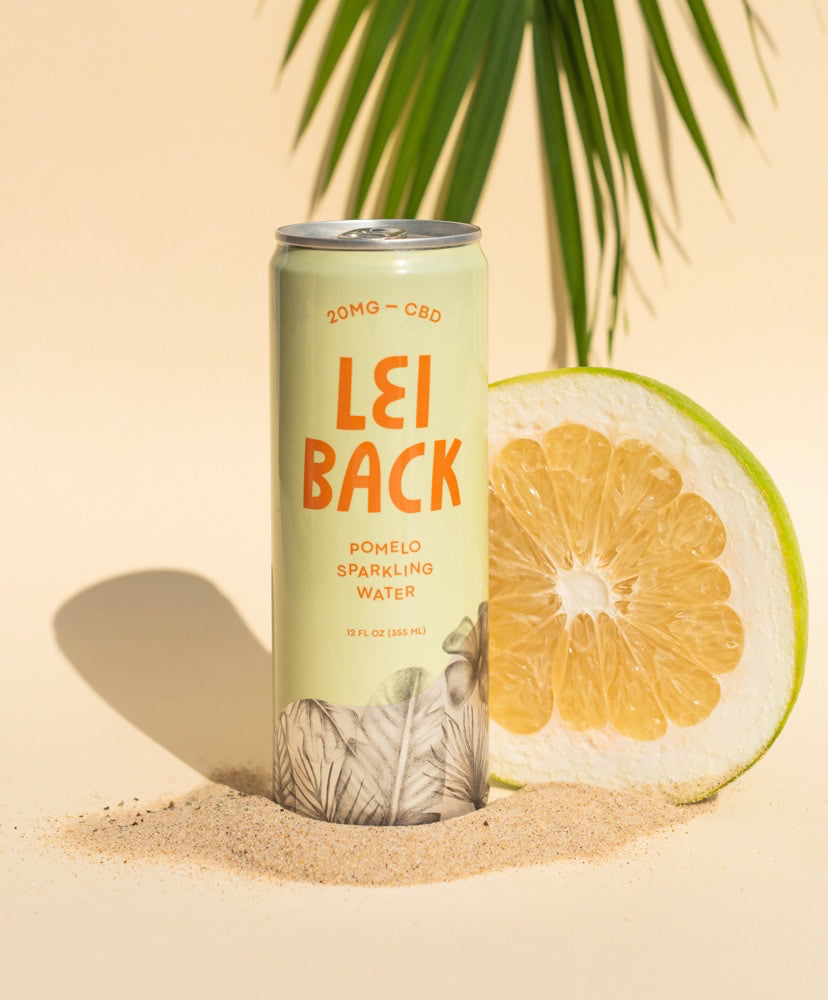 A can of Lei Back Pomelo Sparkling water with a bisected Pomelo in the background